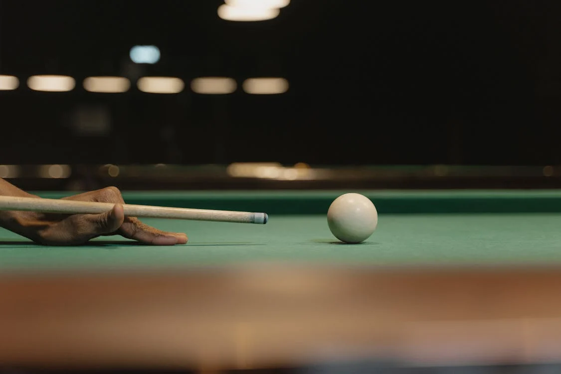 Close-up shot of a person hitting a cue ball
