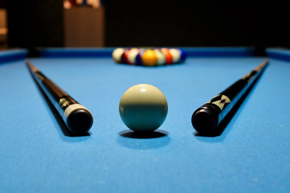 Billiard table with cue sticks on top