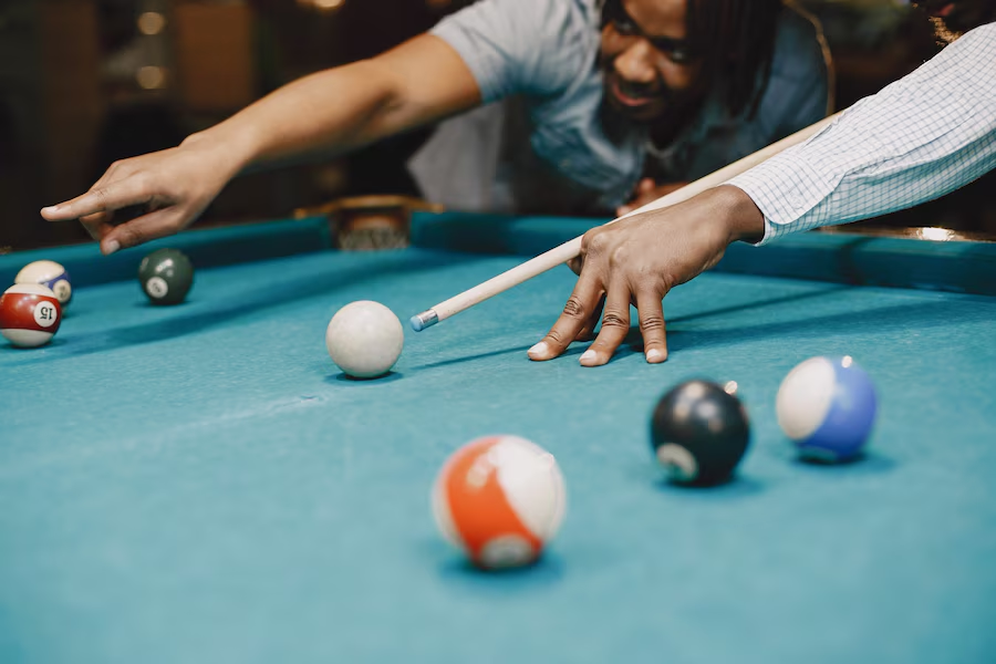 Men playing billiards with cue sticks